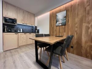 a kitchen with a wooden table and chairs at Apartmány Panorama Harrachov in Harrachov