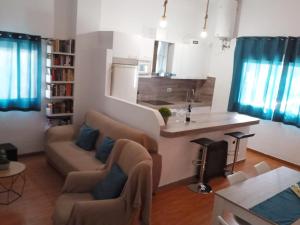 a living room with a couch and a kitchen at Alojamiento rural El Yate in Montefrío