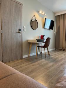 Cette chambre comprend une table, une chaise et un miroir. dans l'établissement Luxor Premium Suites, à Thessalonique