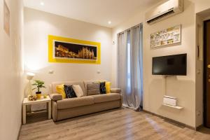 Lemon Suite - Fiera Milano - City Life في ميلانو: غرفة معيشة مع أريكة وتلفزيون