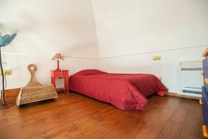 a bedroom with a red bed and a table with a lamp at Bilocale Elena 40mq in Conca dei Marini