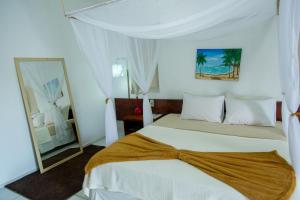 a white bedroom with a bed and a mirror at Delta Park Hotel in Parnaíba