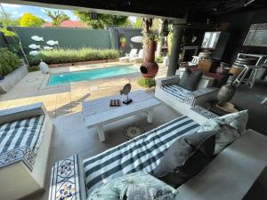 a patio with two couches and a table and a pool at Roads End in Benoni