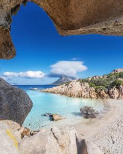 a view of a beach with rocks and the ocean at A due passi olbia in Olbia