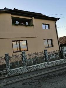 a house with a fence in front of it at Casa Alex in Topliţa