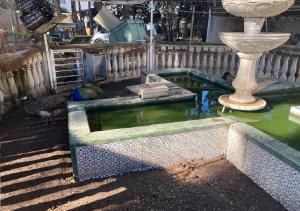 a fountain with a vase in the middle of a pond at Habitacion en casa rural particular el Palomar in Villena +14 photos