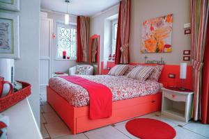 a red bedroom with a red bed with a red blanket at Casa Novecento in Feltre