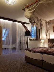 a bedroom with a bed with a canopy and a lamp at Ritterhof Kampehl in Neustadt