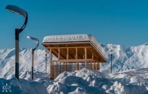 a building in the snow with two street lights at New Gudauri Atrium Ski and Dream Apartment in Gudauri