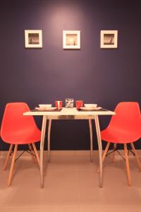 シュチェチンにあるStudencki Dom Marynarza Pasatのダイニングルームテーブル(赤い椅子2脚、カップ付きテーブル付)