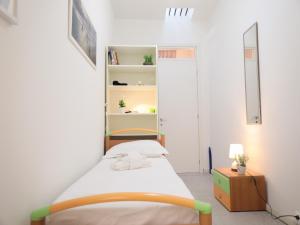 um pequeno quarto com uma cama e uma estante de livros em PRATO DELLA VALLE STUDIO em Pádua