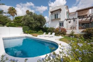 a swimming pool in front of a house at Villa Mimosa in Marbella