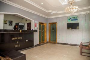 a woman standing in a room with a mirror at Emmy Hotels & Suites in Lekki