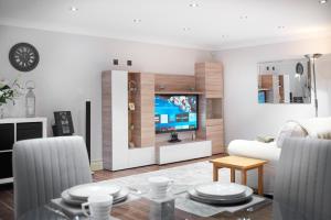 uma sala de estar com um sofá e uma televisão em Bridge House Apartment. Luxury and cosy self contained apartment. em South Luffenham