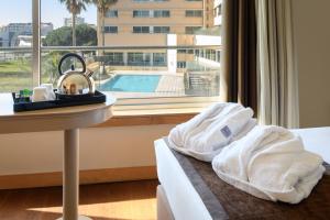 a hotel room with a bed and a sink and a window at TRYP by Wyndham Porto Expo Hotel in Leça da Palmeira