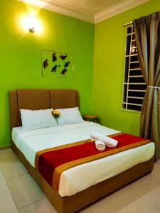 um quarto com uma cama grande e paredes verdes em SHAHBANDAR HOMESTAY em Bentong