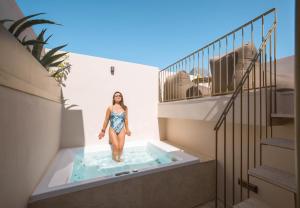 a woman standing in a swimming pool on a building at Neratze Hammam Suites in Rethymno Town