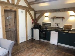 a kitchen with black counters and white appliances at Le Séchoir in Beaulieu-sur-Dordogne