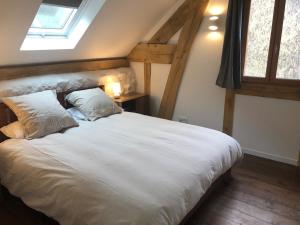 a bedroom with a large white bed with two pillows at Le Séchoir in Beaulieu-sur-Dordogne