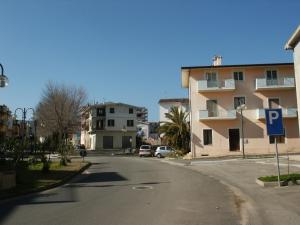 an empty street with a building and a parking lot at Casa Maria in Cardedu