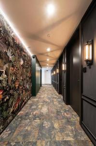 a hallway with a carpeted floor and paintings on the walls at JS-Balingen in Balingen