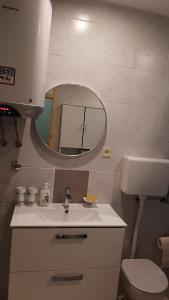 uma casa de banho com um lavatório, um espelho e um WC. em Beautiful place near the sea em Podstrana