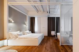 a bedroom with a white bed and a bath tub at JS-Balingen in Balingen