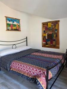 a bedroom with a bed and a painting on the wall at Chèvres à Cheval - Apartment in Aosta