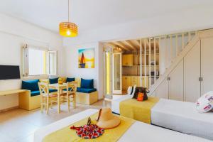 Schlafzimmer mit einem Bett, einem Tisch und Stühlen in der Unterkunft Aelia Apartments & Suites in Livadi Astypalaias