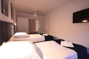 a hotel room with three beds and a flat screen tv at Studencki Dom Marynarza Pasat in Szczecin
