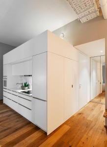 uma grande cozinha branca com armários brancos e pisos de madeira em JS-Balingen em Balingen