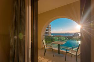 a room with a balcony with a table and chairs at Smy Carlos V Wellness & Spa Alghero in Alghero