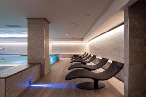 una fila de sillas sentadas en una fila en una habitación en Smy Carlos V Wellness & Spa Alghero, en Alghero