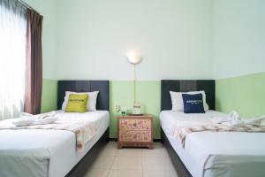 Voodi või voodid majutusasutuse Urbanview Hotel de Kopen Malang by RedDoorz toas