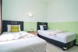Voodi või voodid majutusasutuse Urbanview Hotel de Kopen Malang by RedDoorz toas
