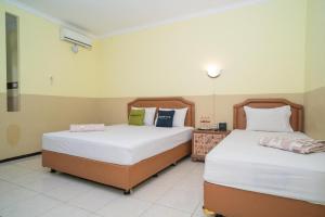 Voodi või voodid majutusasutuse Urbanview Hotel de Kopen Malang by RedDoorz toas