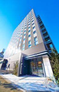 a large tall building with a entrance to it at Keisei Richmond Hotel Tokyo Kinshicho in Tokyo