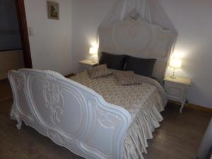um quarto com uma grande cama branca e duas mesas em Chez Len & Filipp em Bouillon