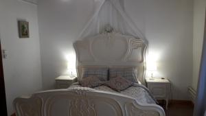 um quarto com uma cama branca com duas mesas de cabeceira em Chez Len & Filipp em Bouillon