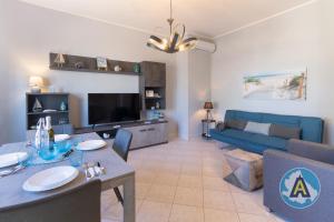 a living room with a blue couch and a tv at Casa Del Bello - Appartamento di fronte al mare a Silvi in Silvi Marina