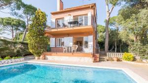 a villa with a swimming pool in front of a house at Est Benet - Calella de Palafrugell in Calella de Palafrugell