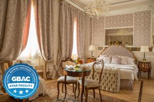 a hotel room with a bed and a table and chairs at Grand Hotel Majestic gia' Baglioni in Bologna