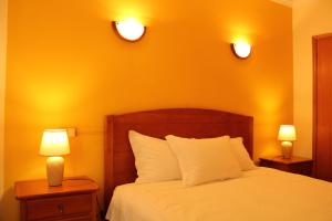 een slaapkamer met een bed met twee lampen op twee tafels bij Canto do Rossio in Vidigueira