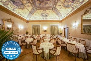 un restaurante con mesas y sillas en una habitación con techo en Grand Hotel Majestic gia' Baglioni, en Bolonia