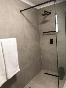 a shower with a glass door and a towel at Hilton Bella Vista in Hilton