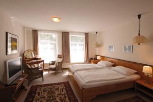 ein Hotelzimmer mit einem Bett und einem TV in der Unterkunft Leisewitz' Garten in Celle