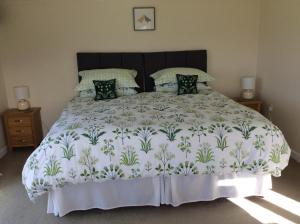 a bedroom with a large bed with a white comforter at Copse Gate Farm in Bridport