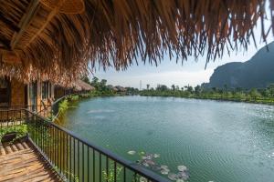 uma vista para um rio a partir de uma varanda de um resort em Halise Home and Retreat Ninh Binh em Ninh Binh