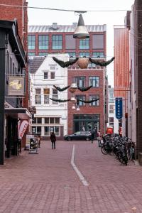 una calle de la ciudad con edificios y gente caminando por la calle en City Stay&Go Enschede, en Enschede