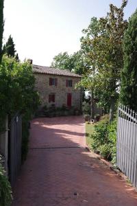 un vialetto di mattoni che conduce a una casa con recinzione di Villa Vestra in Vinci holiday home a Vinci